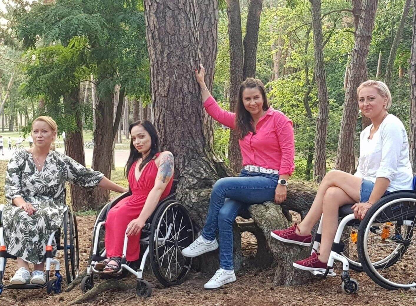 trzy kobiety na wozku inwalidzkim w lesie